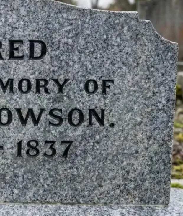 The same DOWSON headstone after cleaning, the lettering crisp again