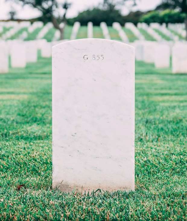 A clean upright marker standing in mown grass