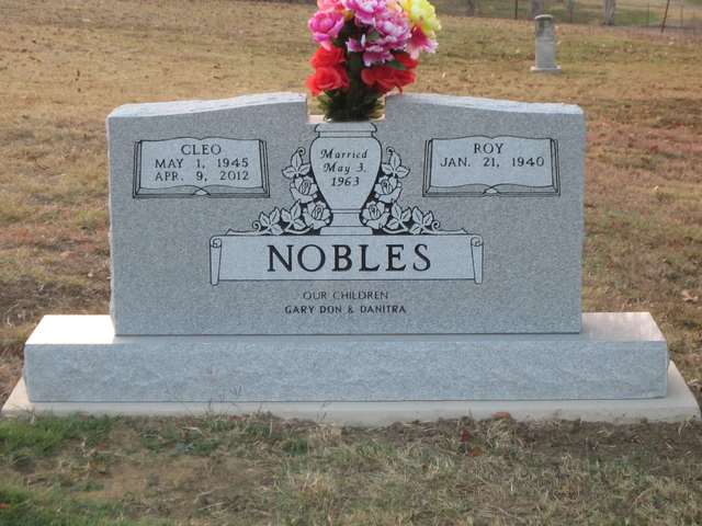 Grey granite headstone with seasonal flowers